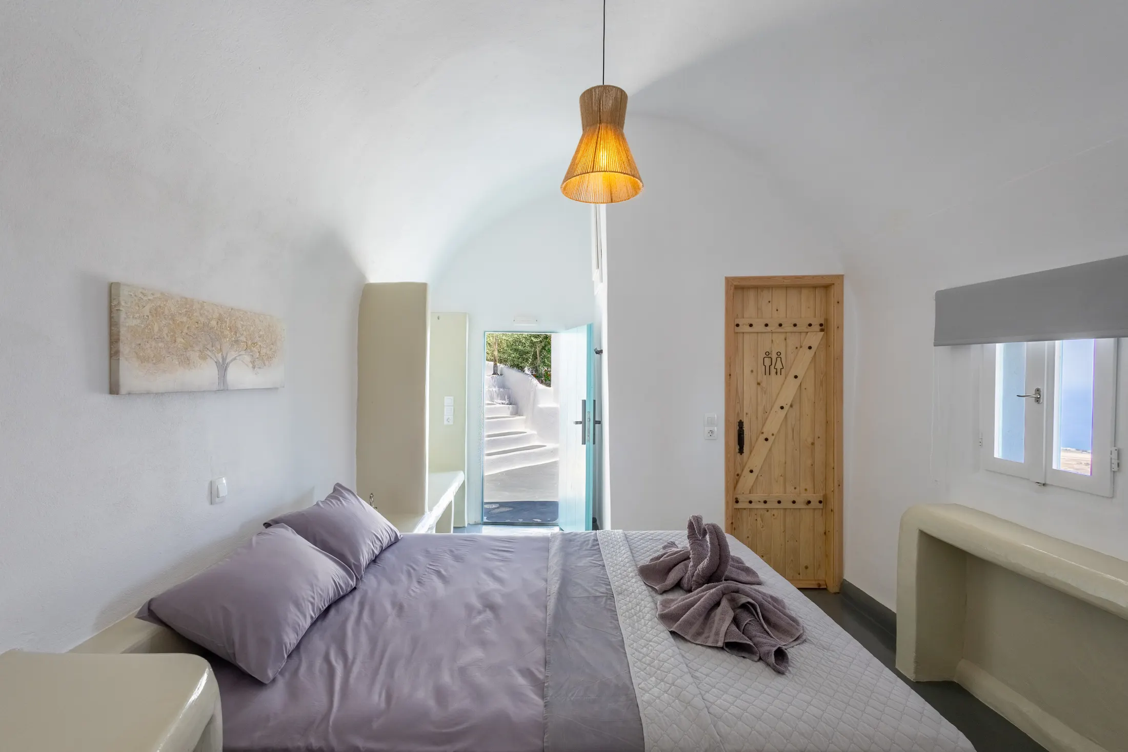 Assyrtiko suite — bedroom with a vaulted cave-style whitewashed ceiling
